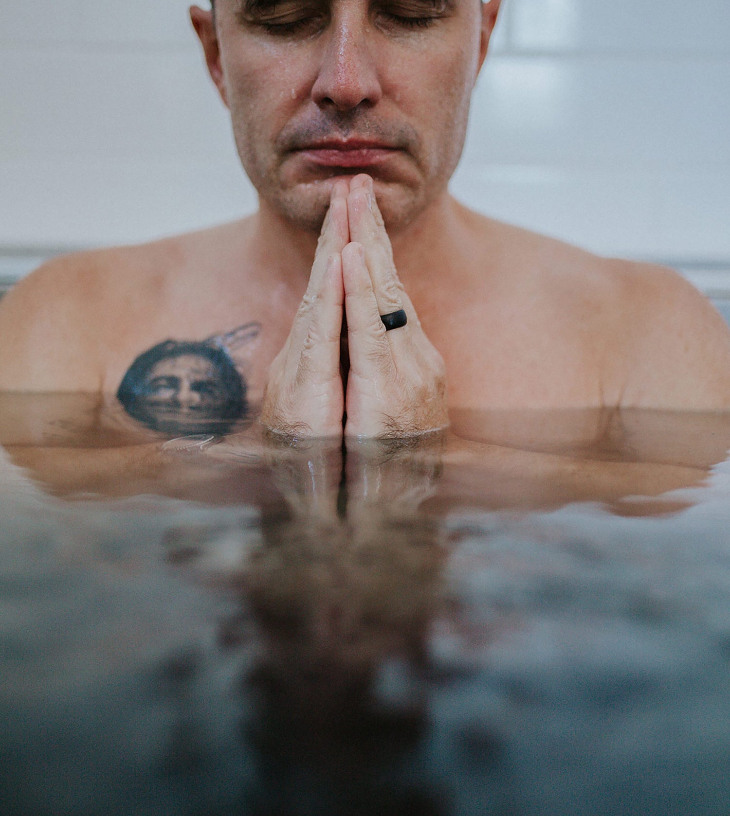 Man praying in cold plunge at Sauna House