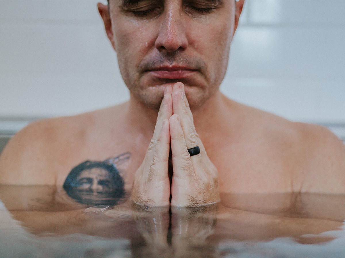 Man praying in cold plunge at Sauna House