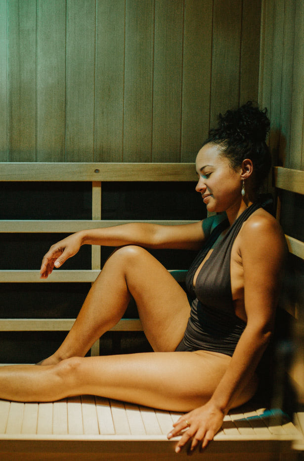 Woman sitting in an infrared sauna with green light