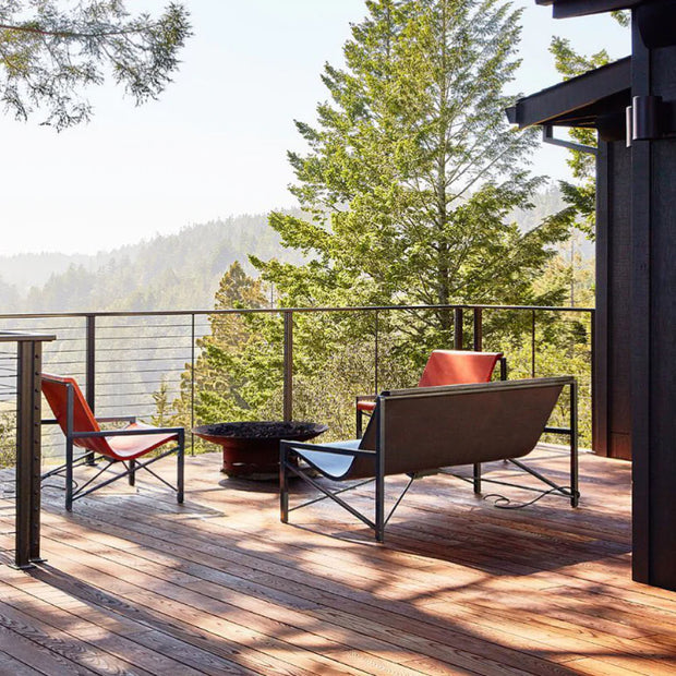 Evia Lounge and 2 Evia Chairs around a fire pit on a porch overlooking the mountains