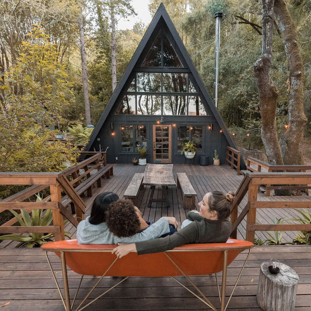 Friends lounging in a Helios Metreo on a porch in the woods