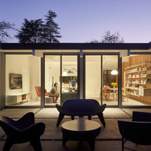 Apollo coffee table, chairs, and lounge on a porch next to a family home