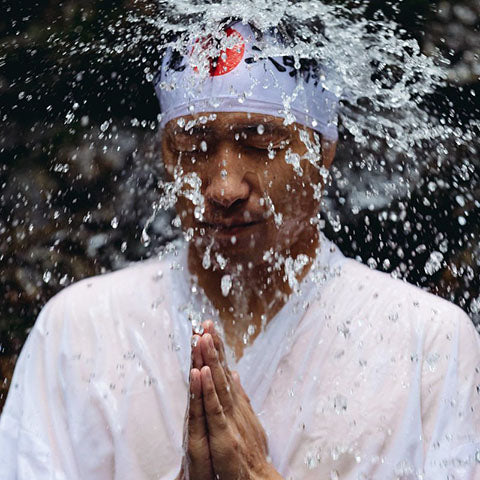 Japanese Man performing a Misoji challenge under a waterfall.