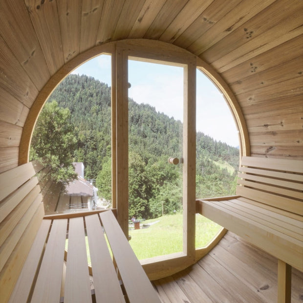 Inside of the SaunaLife barrel sauna with all glass front looking out at a beautiful view
