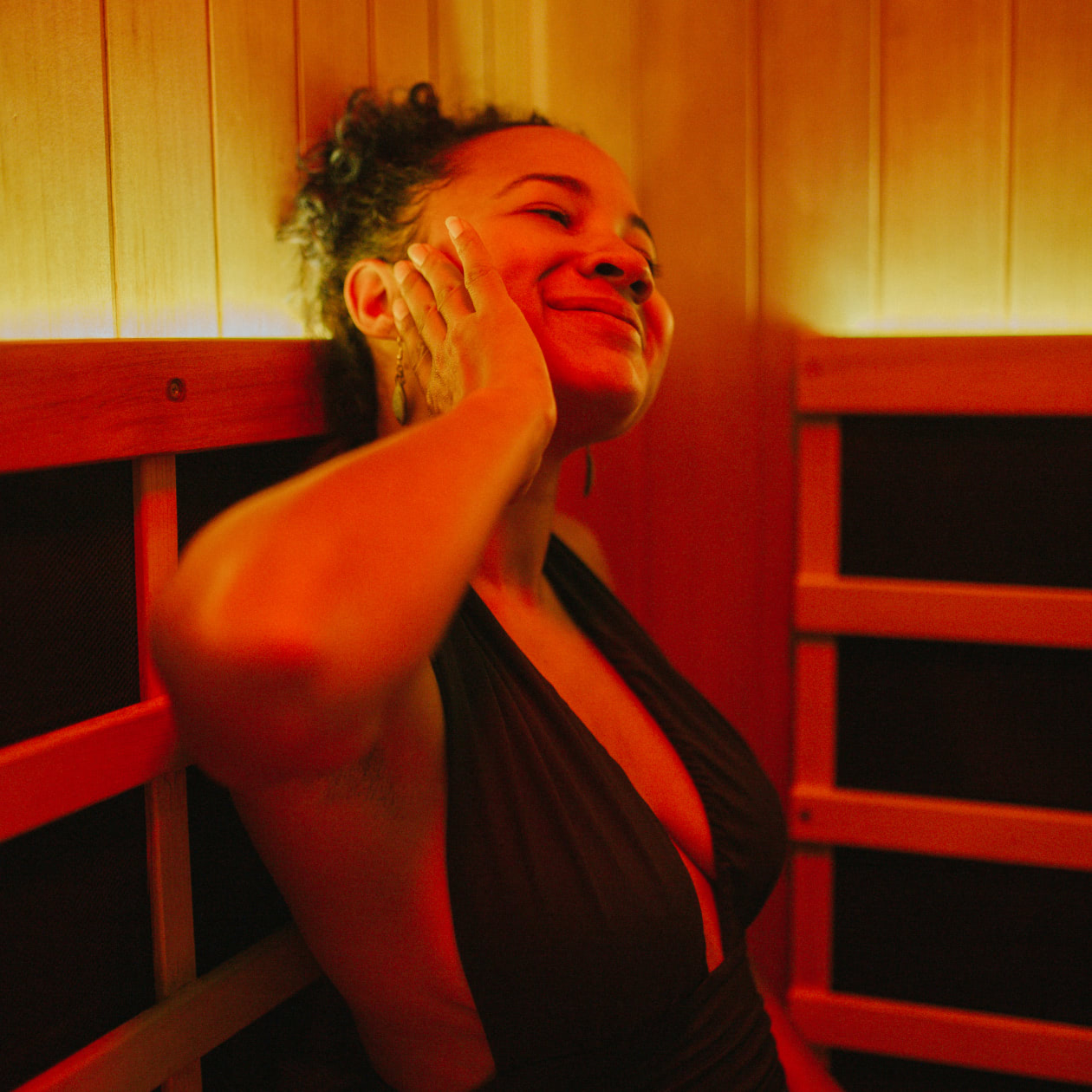 Woman smiling in the infrared sauna getting a good sweat going