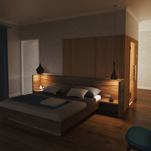 Familia sauna installed in a bedroom behind the bed
