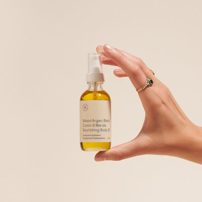 Person holding the mini Naked Argan & Marula Body Oil